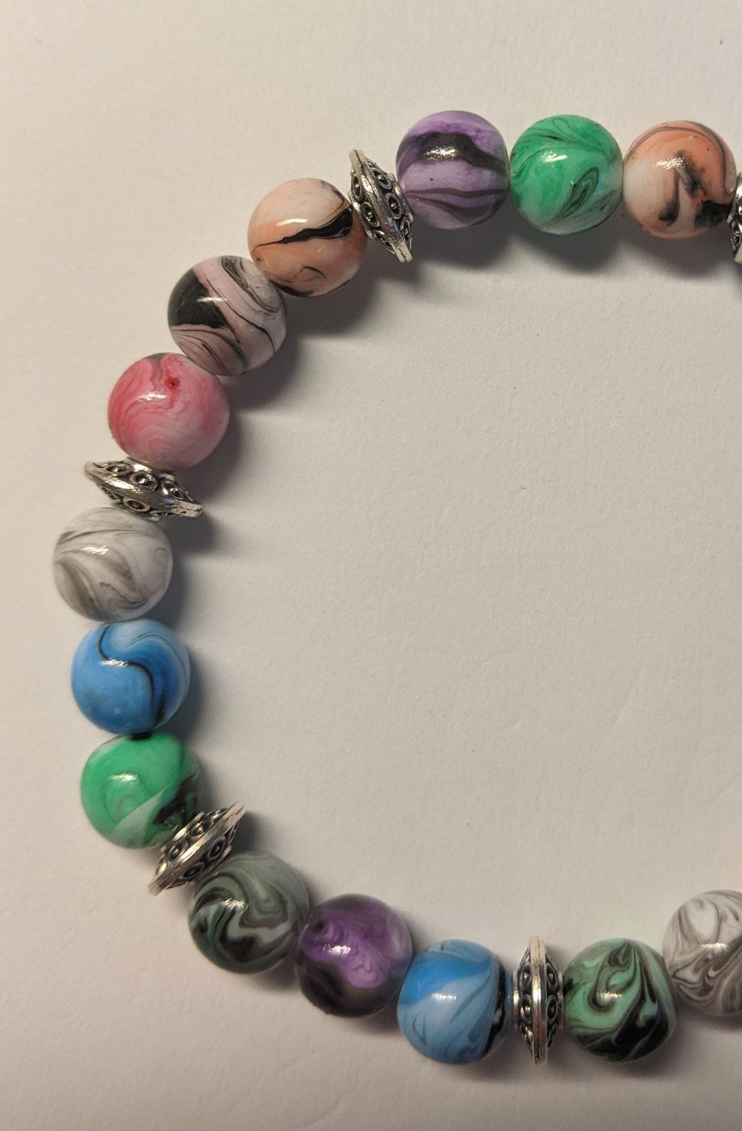 Bracelets - stacker bracelets made with 8-mm multi-colored ink patterned beads, spacer beads, a charm, and durable stretch cord.