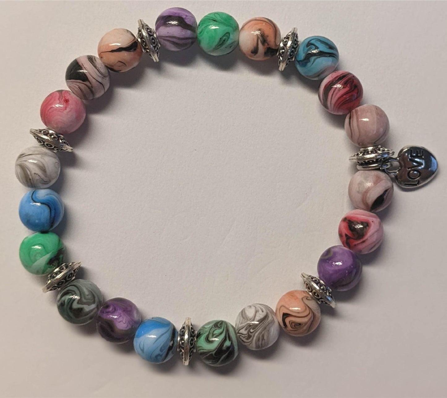 Bracelets - stacker bracelets made with 8-mm multi-colored ink patterned beads, spacer beads, a charm, and durable stretch cord.